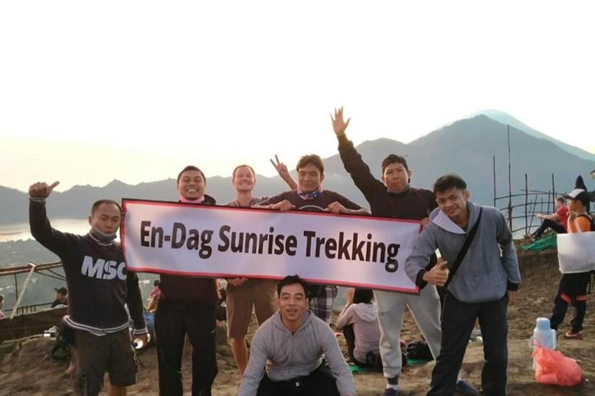 a group of people holding a sign that reads en dog sunrise tracking