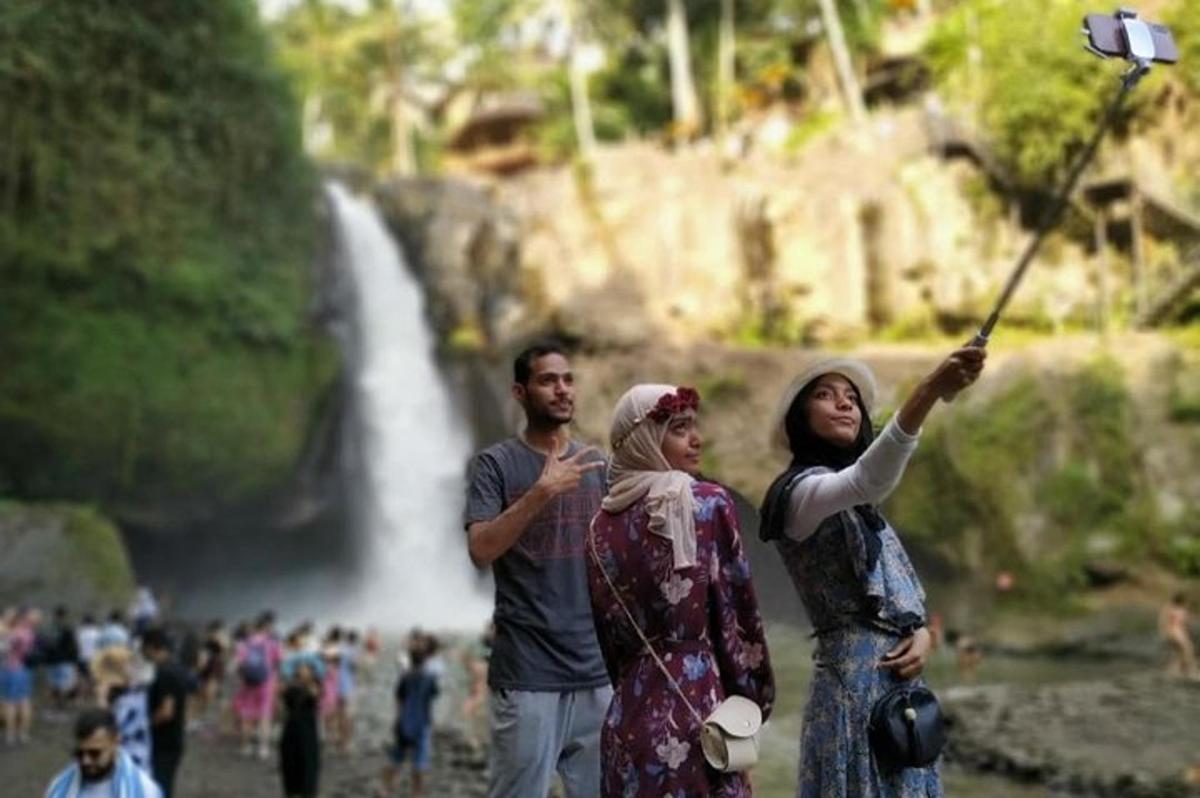 eine Gruppe von Menschen steht vor einem Wasserfall
