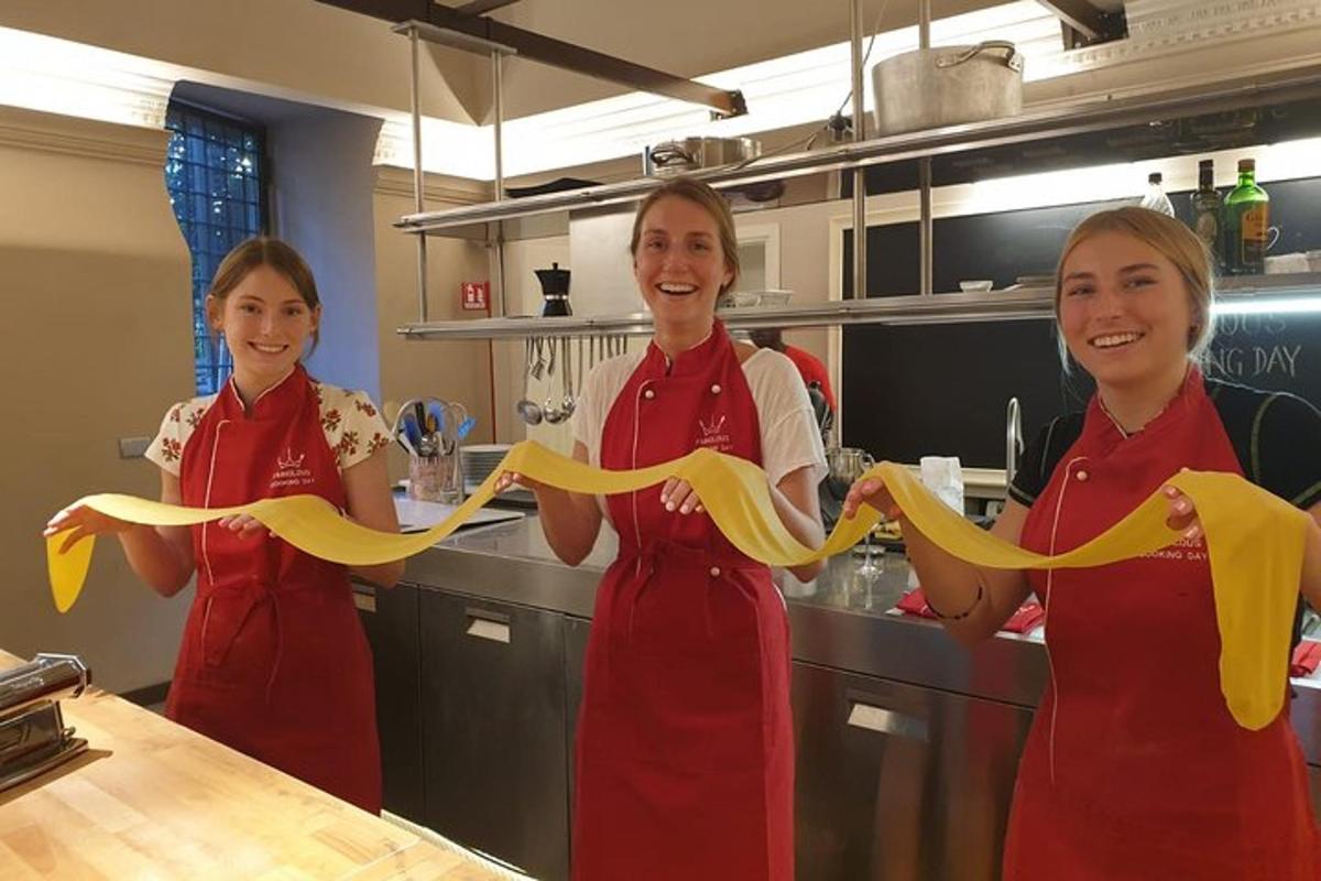 Tres mujeres en una cocina sosteniendo una cinta