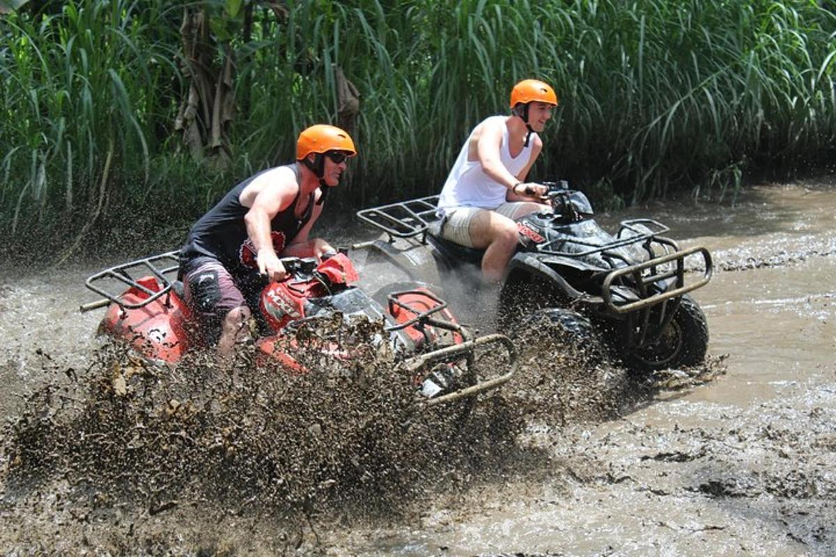 dois homens andando de quadriciclo na água