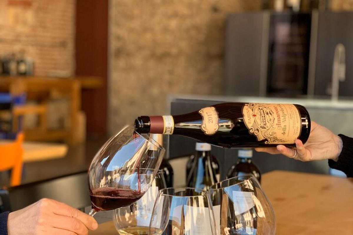 oseba, ki nalije steklenico vina v dva kozarca