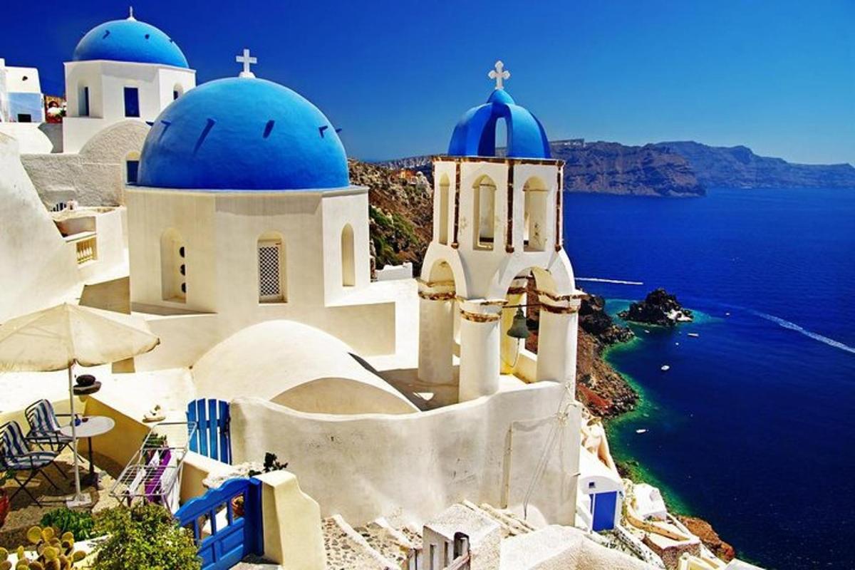 un grup d'edificis blancs amb cúpules blaves i l'oceà