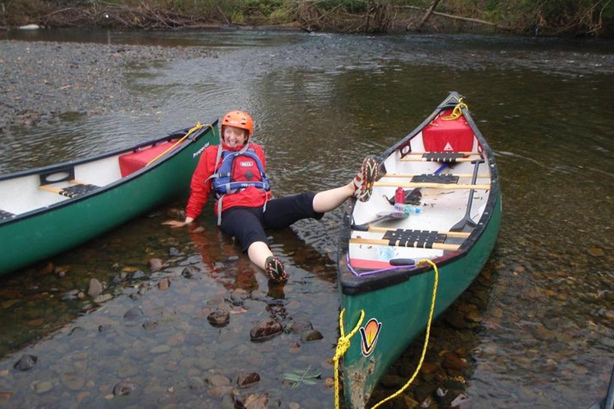 a young boy is sitting in a boat on a river