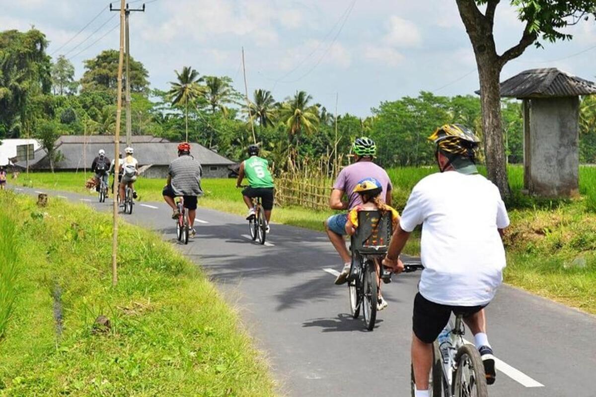 un gruppo di persone che vanno in bicicletta lungo una strada