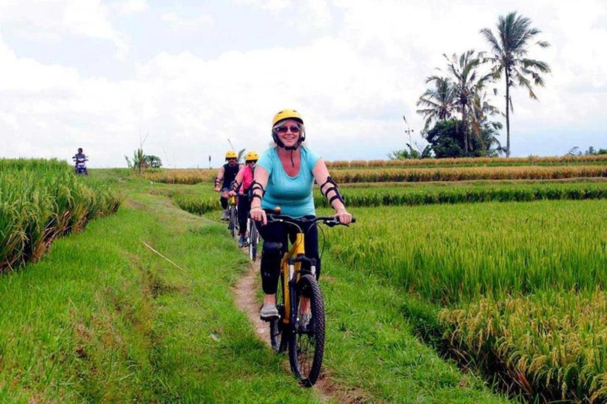 un gruppo di persone che vanno in bicicletta lungo un campo