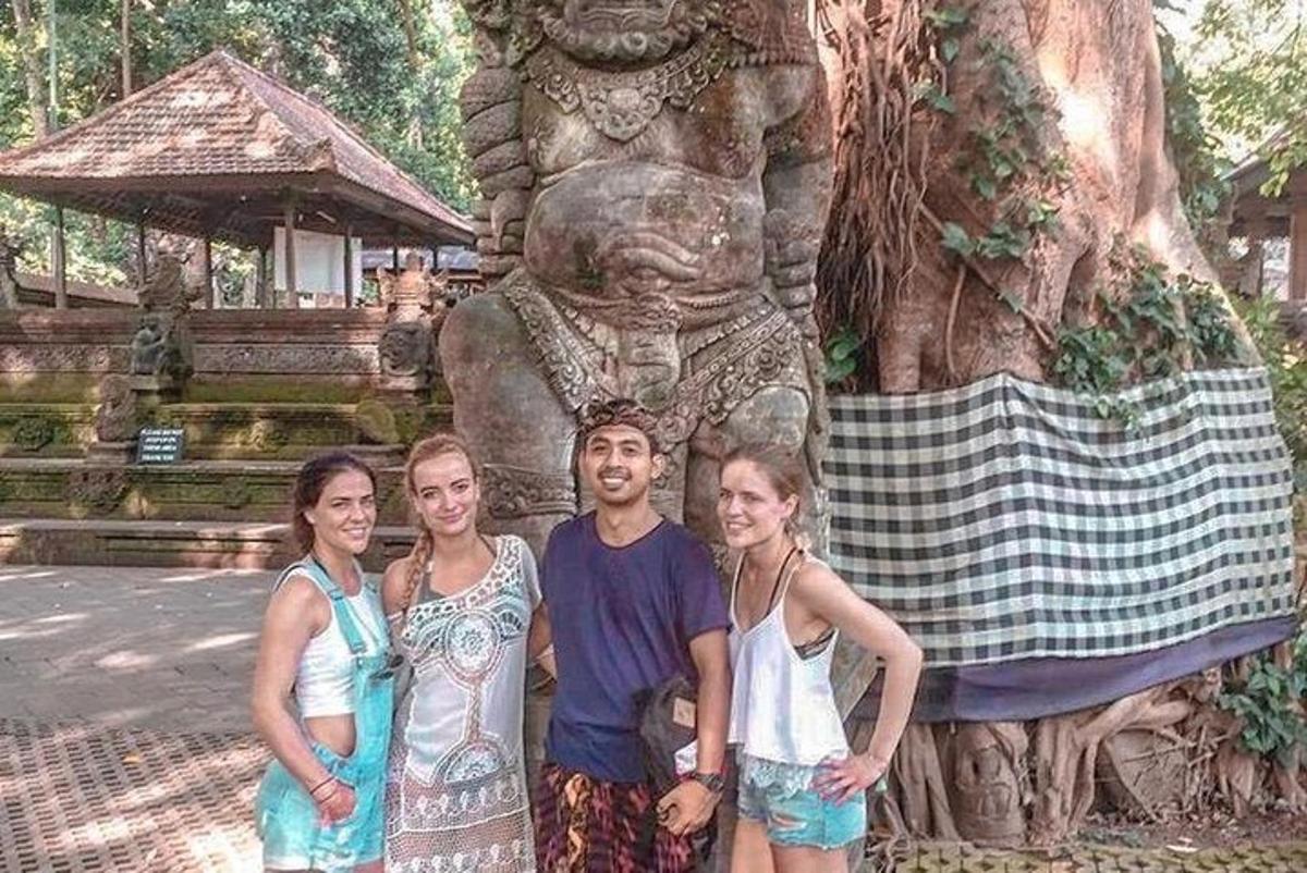sekumpulan orang berdiri di hadapan patung