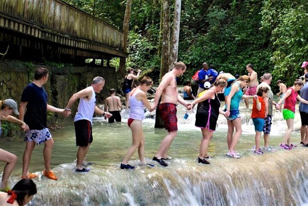 un groupe de personnes debout devant une cascade
