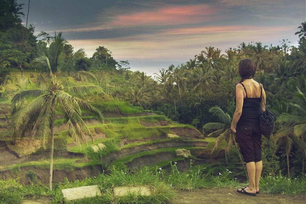 une femme debout sur une colline regardant la jungle