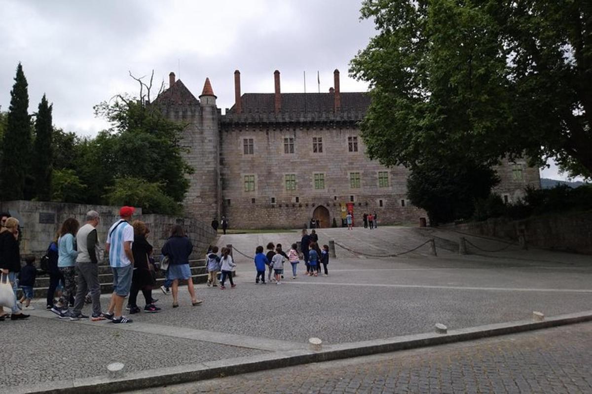 un grup de persones dretes davant d'un castell