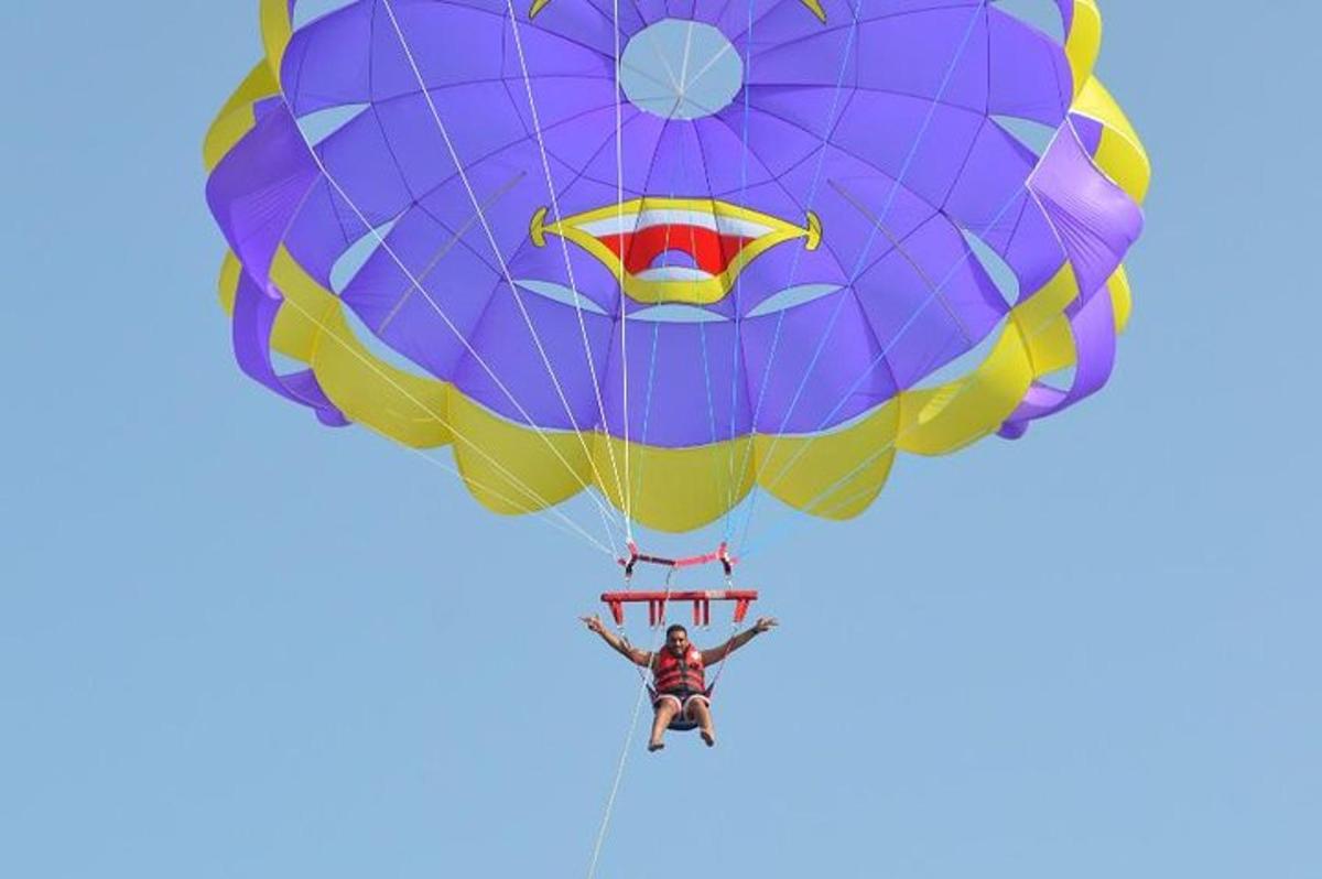 uma pessoa voando de paraquedas no céu