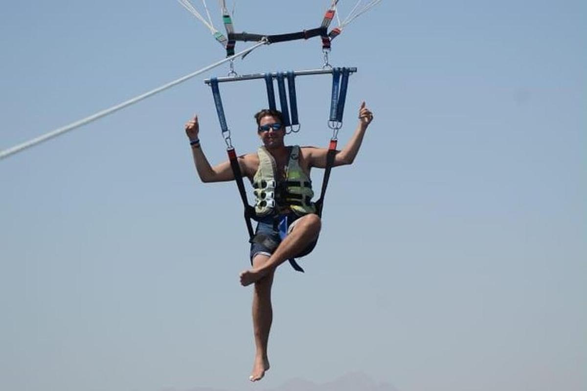một người đàn ông đang đi trên đường trượt zipline bằng dù