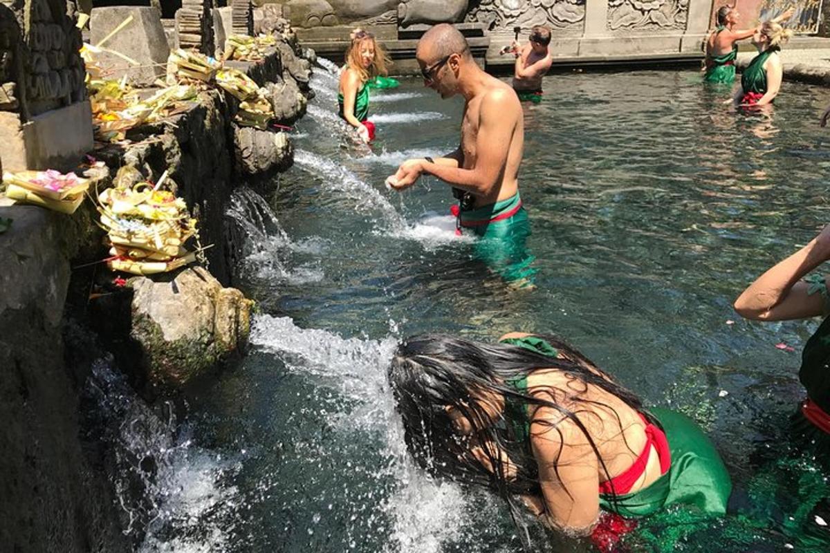 sekumpulan orang di dalam air di air terjun