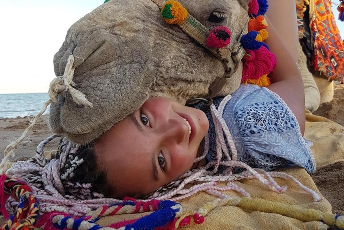 Egy fiatal lány fekszik a tengerparton, fején egy plüssállattal