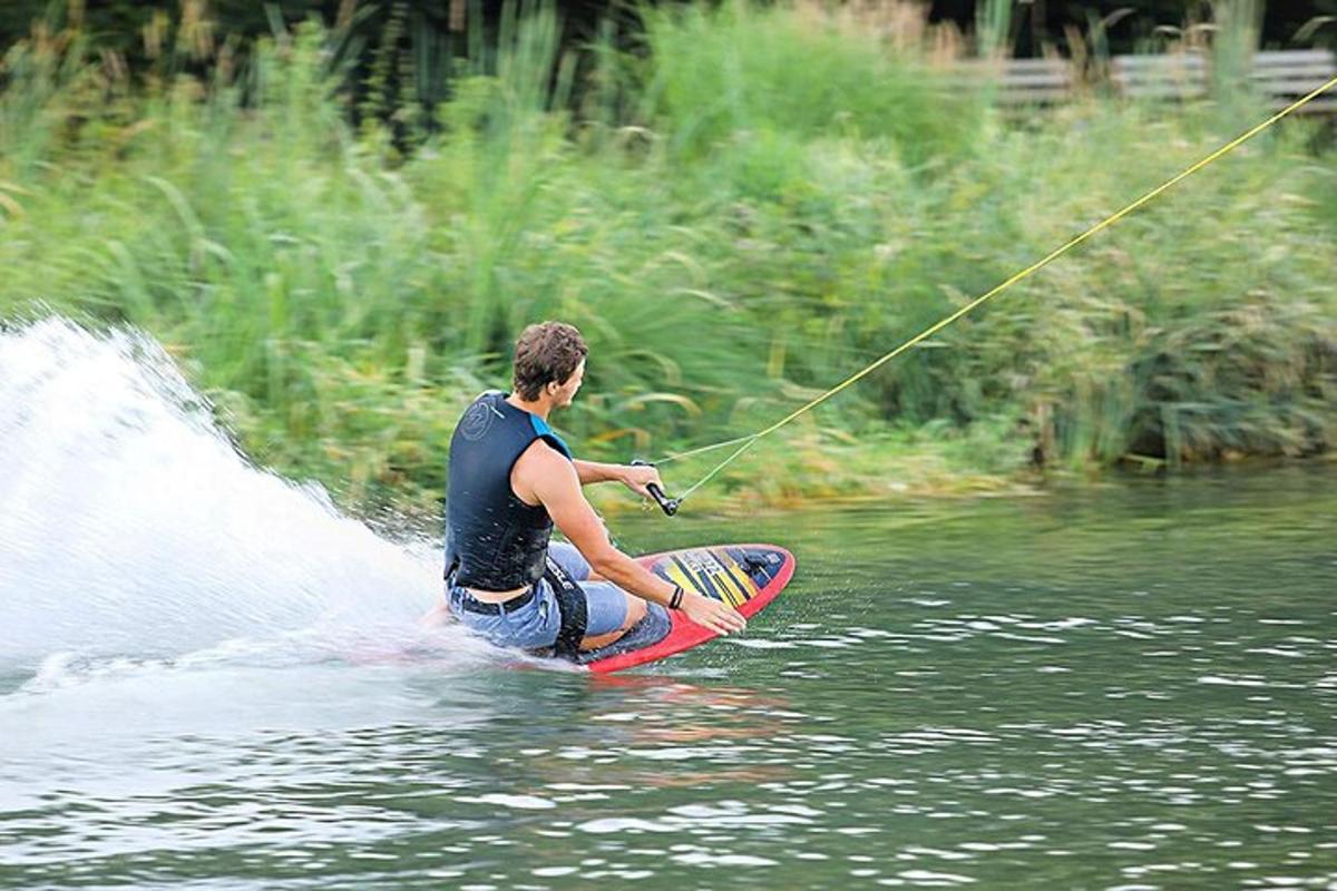 un home sobre una taula de surf a l'aigua