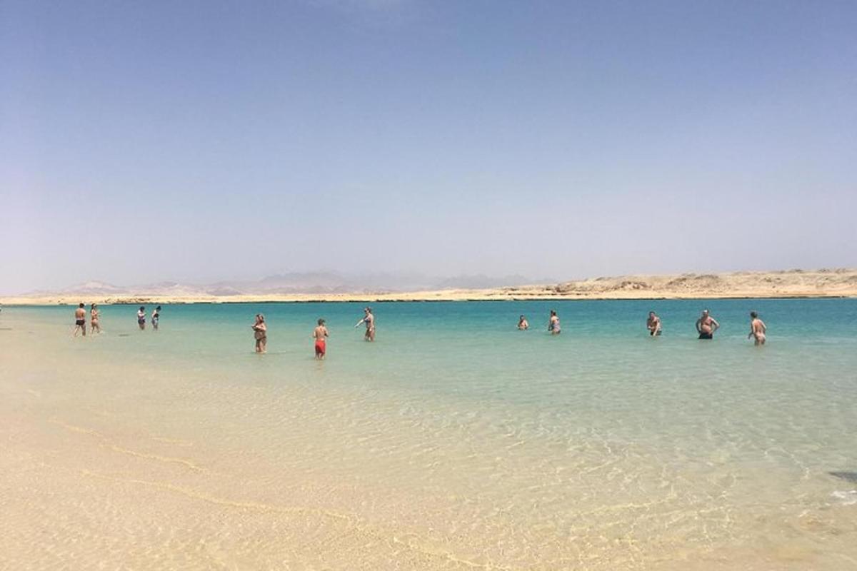 eine Gruppe von Menschen steht im Wasser an einem Strand
