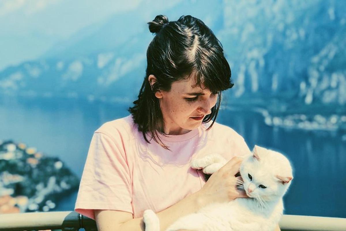 Una mujer sosteniendo un gato blanco en sus brazos
