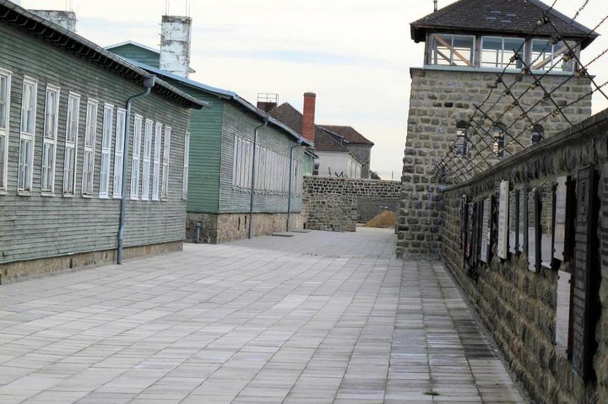 an empty street with a brick wall and a building