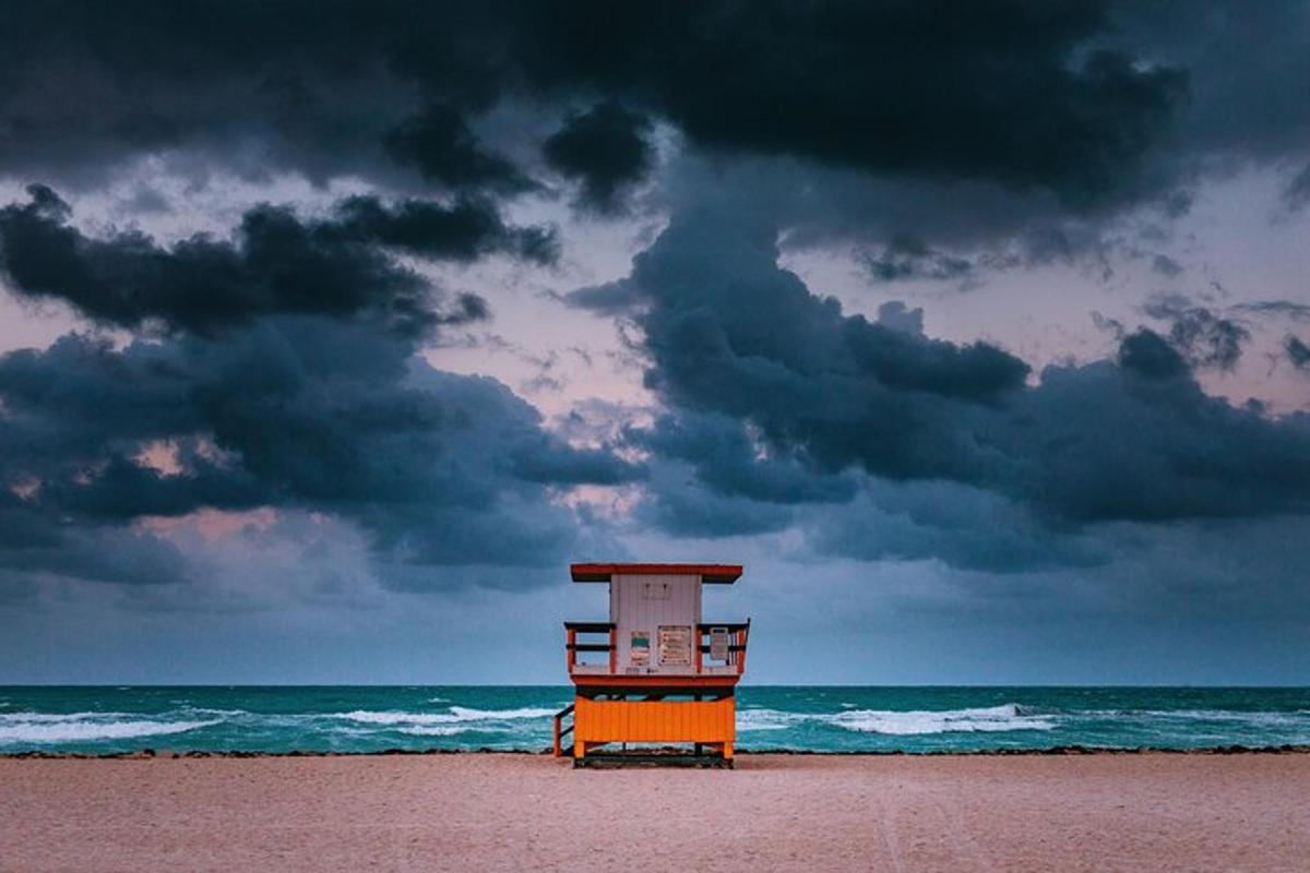a lifeguard tower on the beach under a cloudy sky