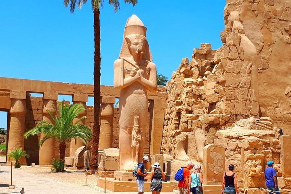 Un grupo de personas de pie frente a una estatua