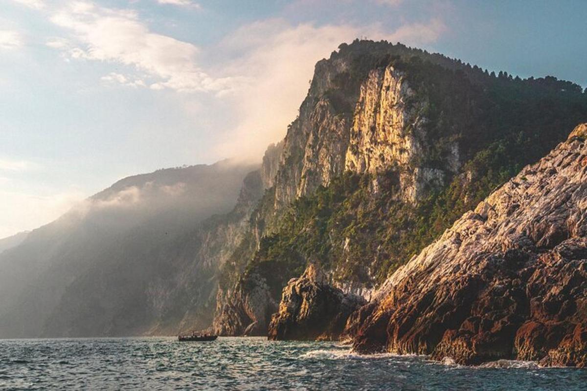 a rocky mountain with a boat in the water