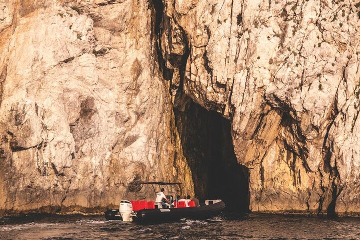 a group of people in a boat in front of a cave