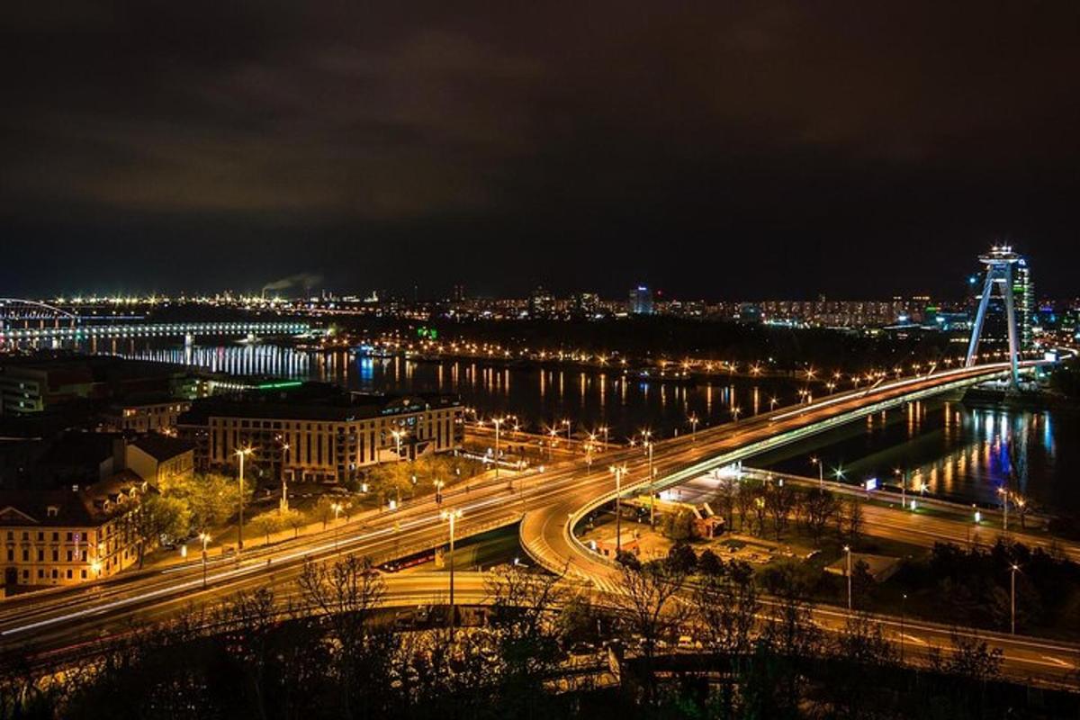 una città illuminata di notte con un ponte