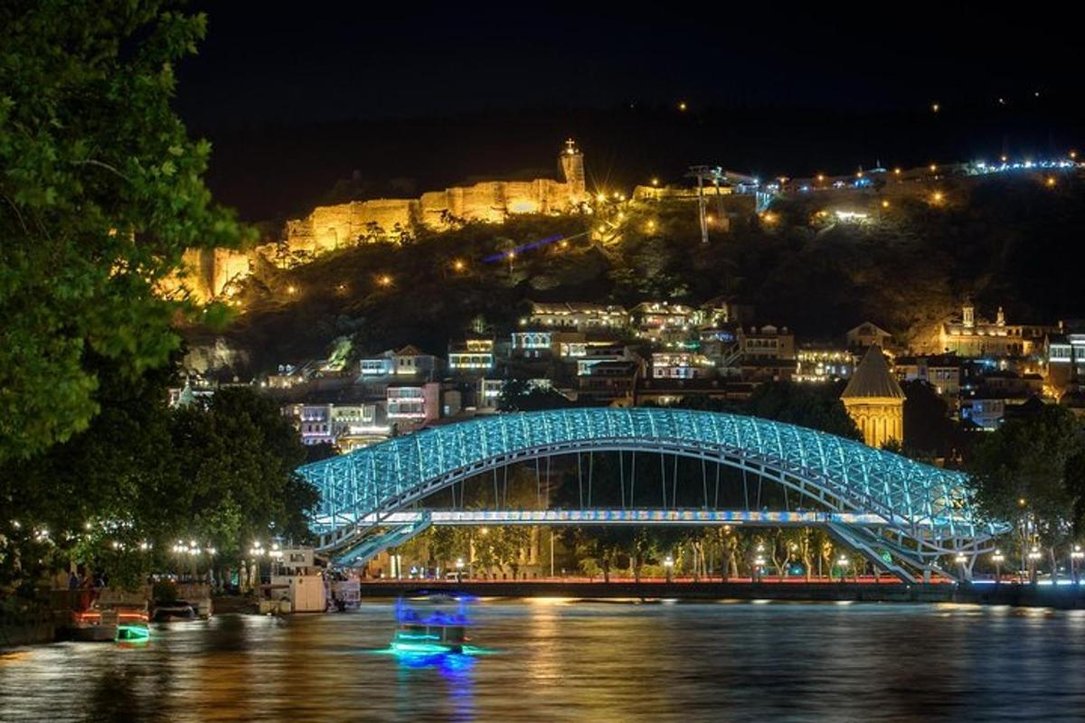 un ponte blu sopra un fiume con una città di notte