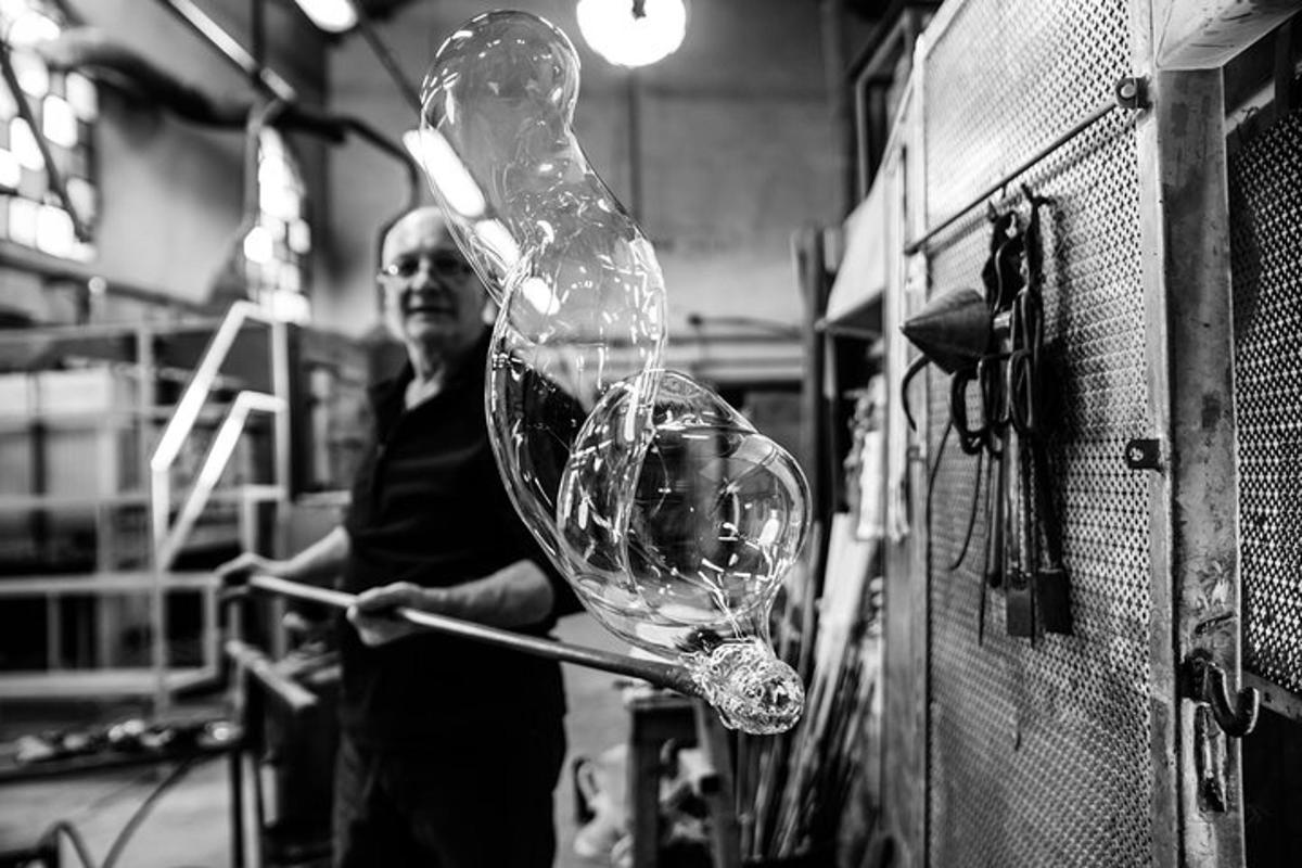 a man in a factory working on a glass bottle