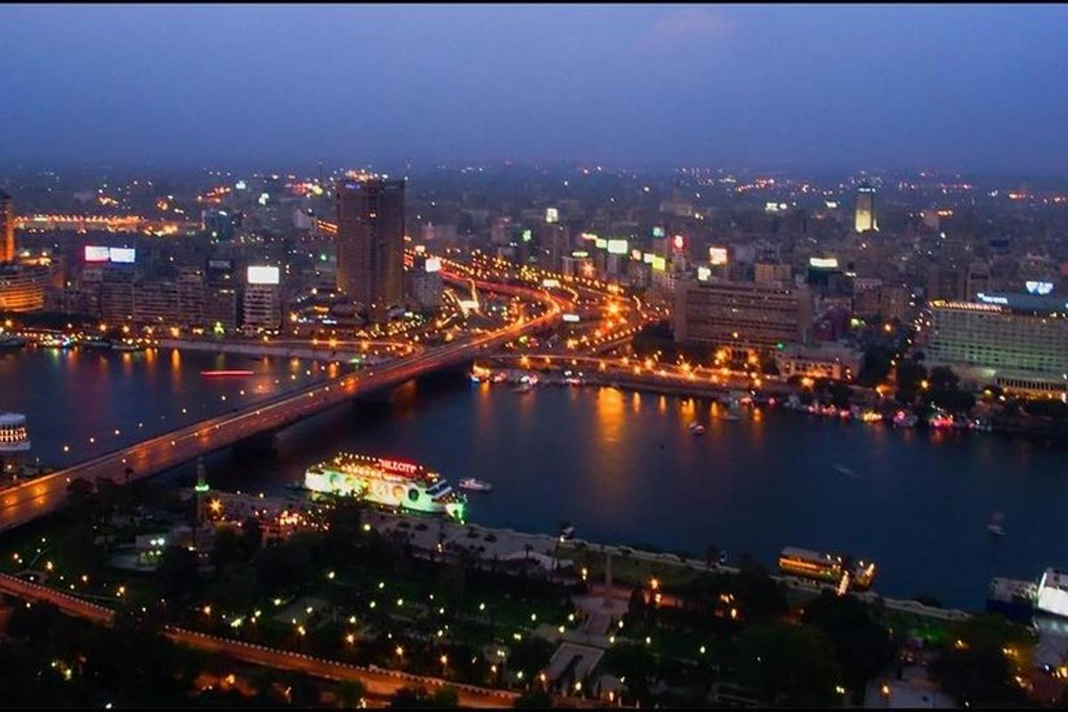a city at night with a river and a bridge