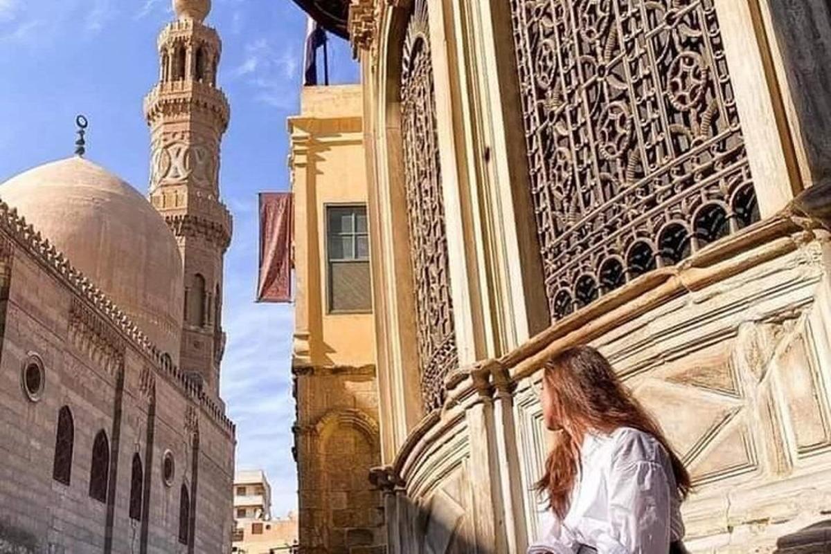 a woman standing in front of a building with a mosque
