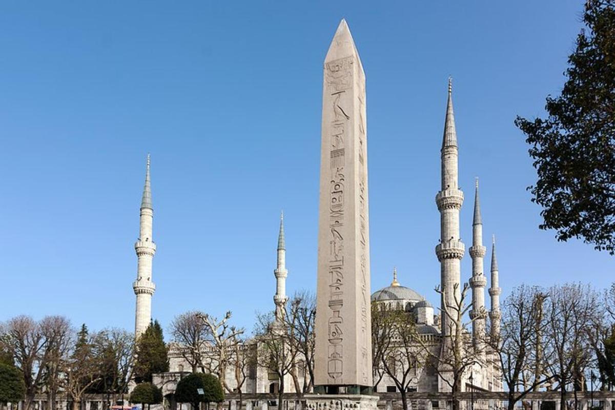 vysoký monument před budovou se dvěma mešitami