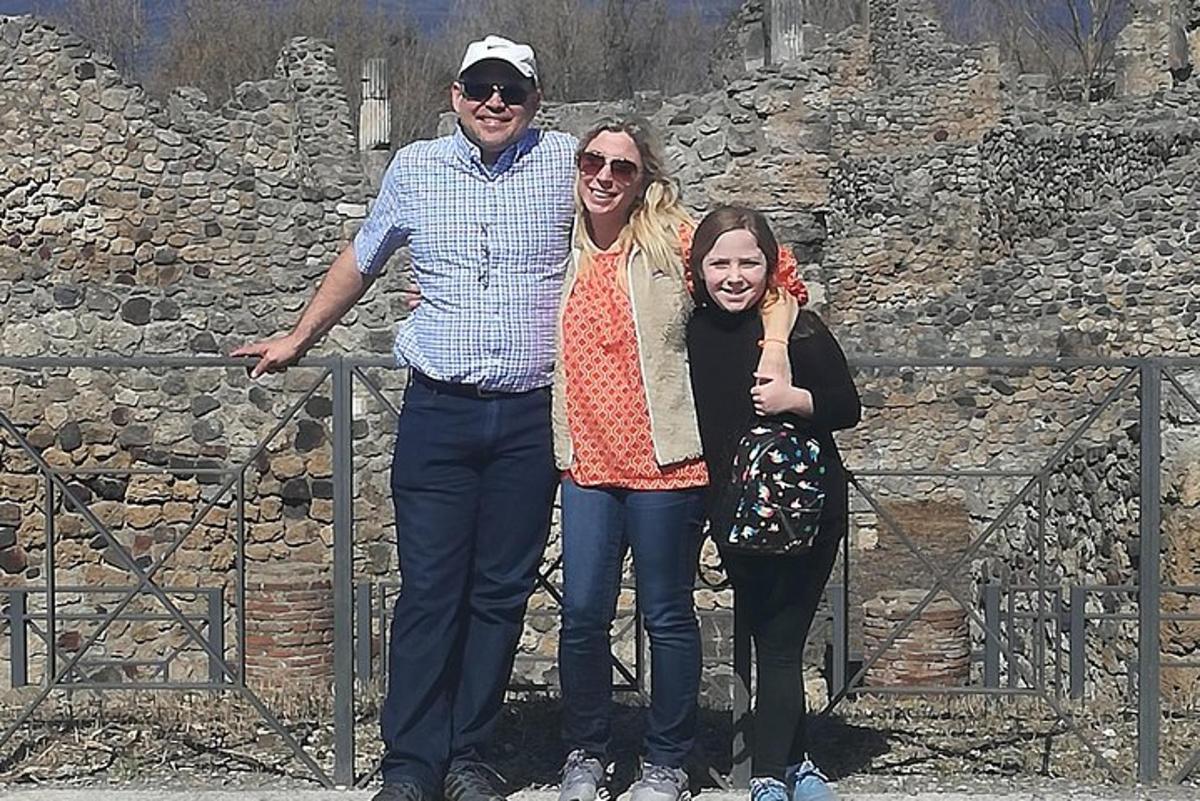 moški in dve ženski stojita pred zidom
