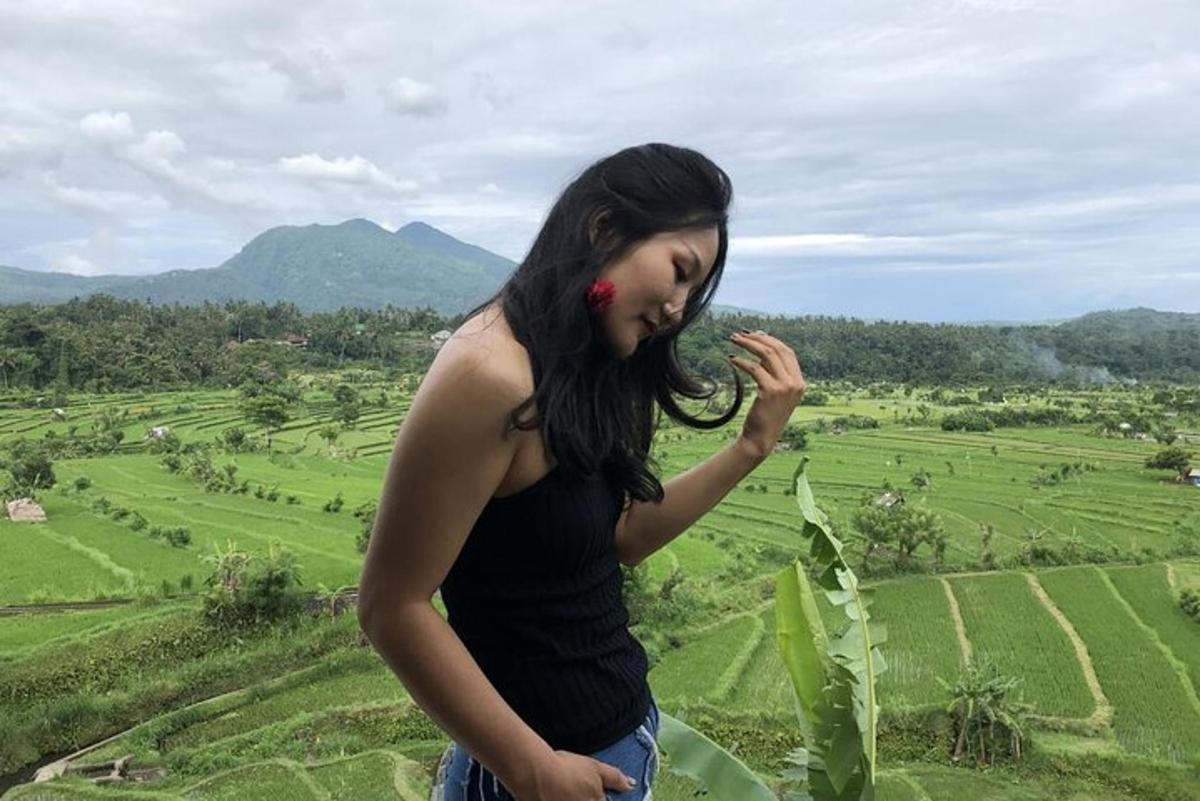 uma mulher parada em uma colina olhando para um campo
