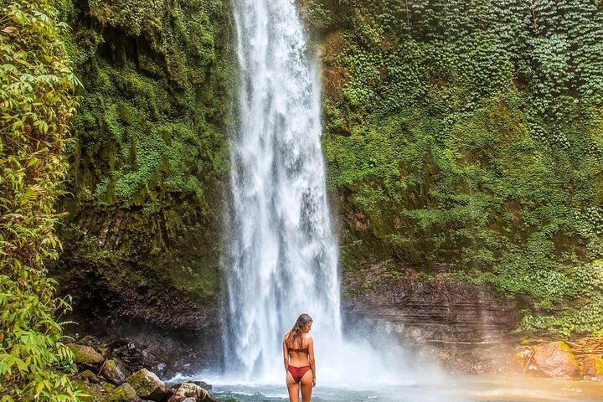 een vrouw die voor een waterval staat