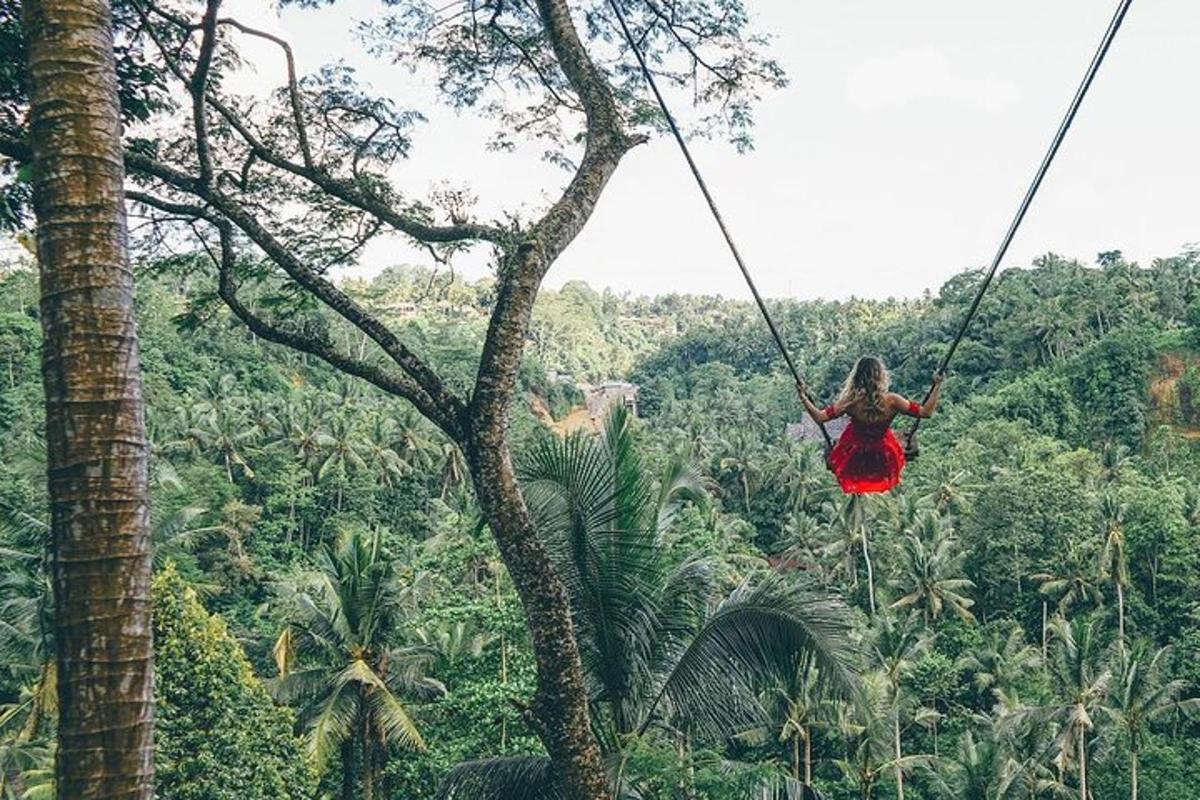 een vrouw in een rode jurk die aan een kabelbaan in de jungle slingert