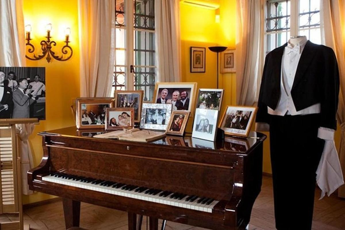 un manichino in piedi accanto a un pianoforte con delle foto sopra