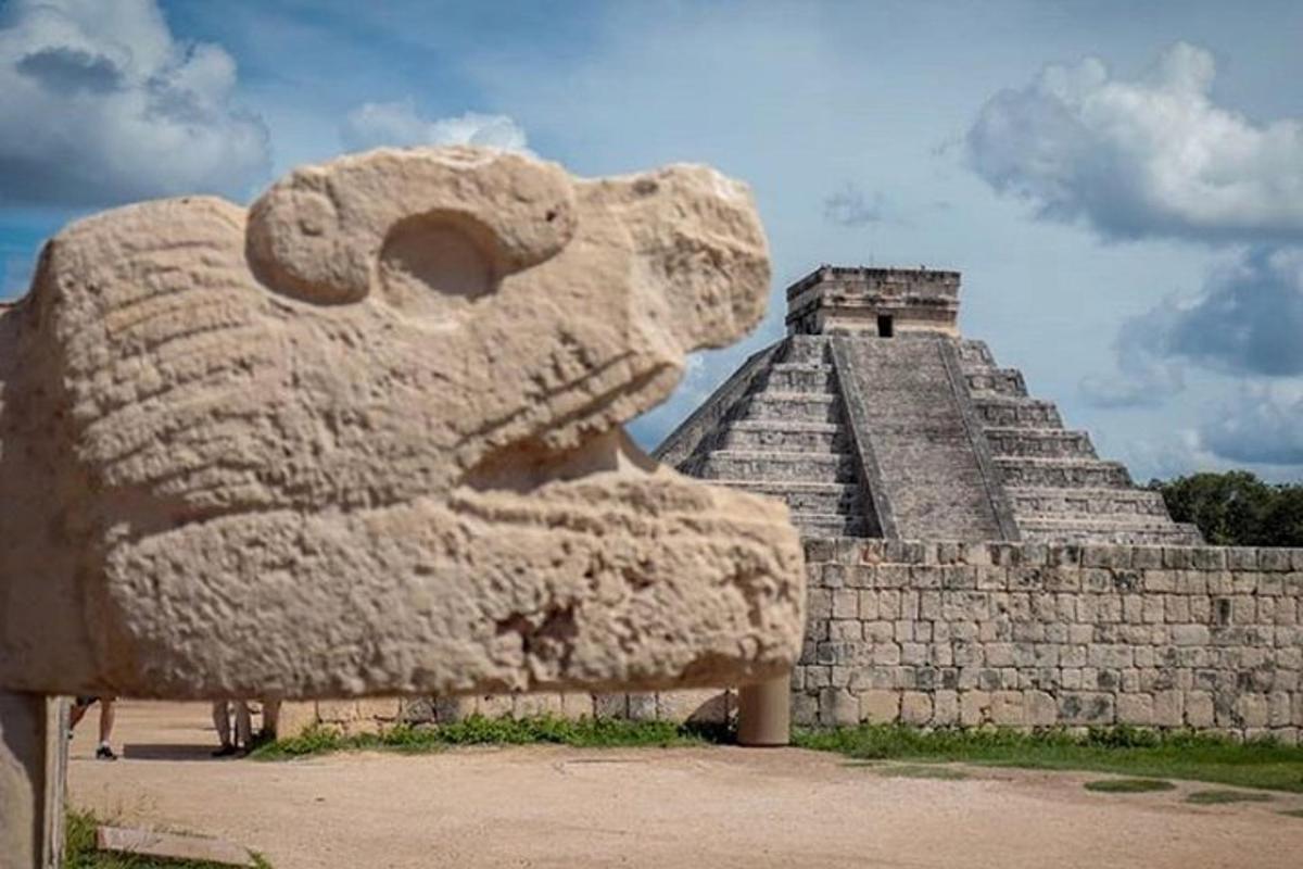 una grande statua di un leone di pietra di fronte a una piramide
