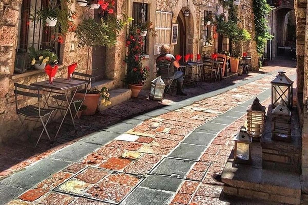 Una calle de piedra con mesas y sillas en un callejón.