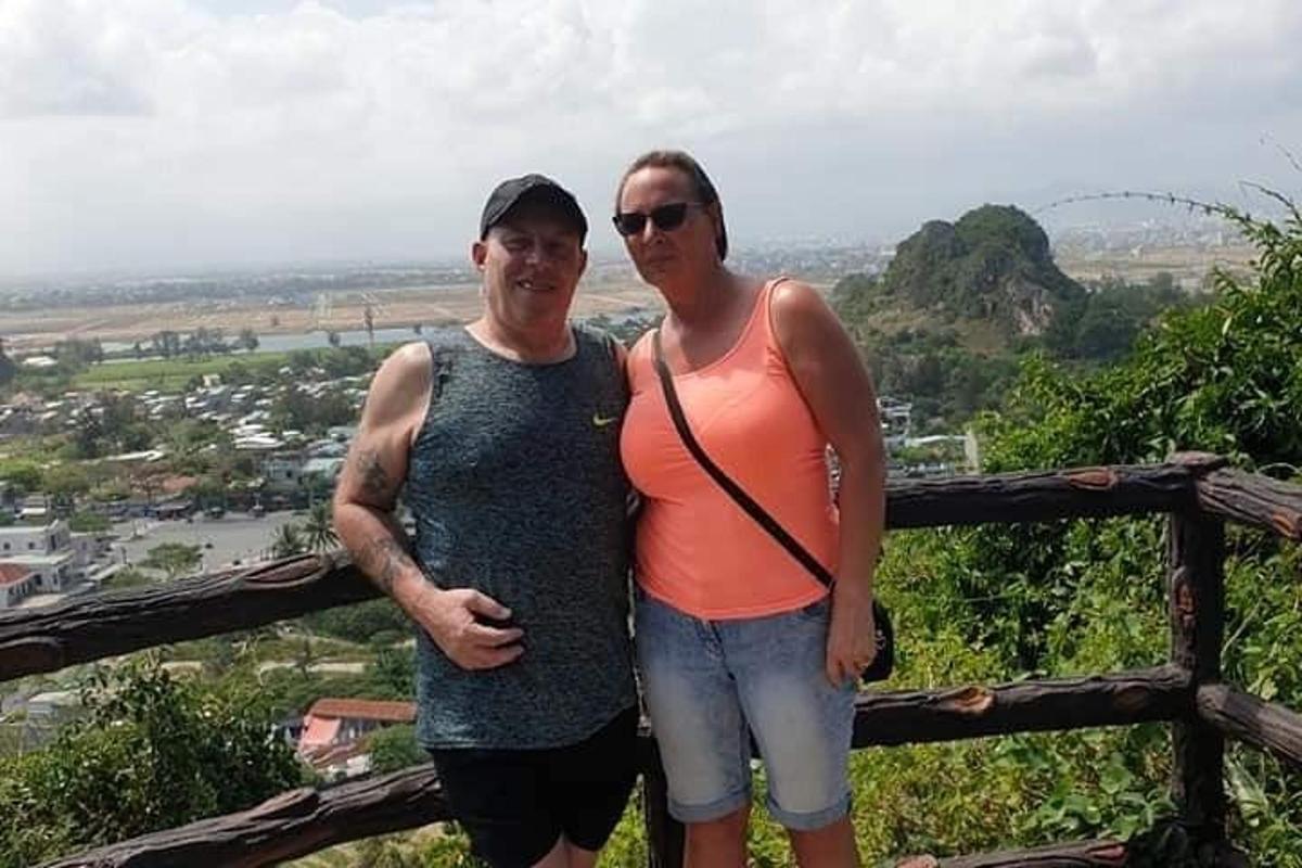 um homem e uma mulher em pé no topo de uma cerca