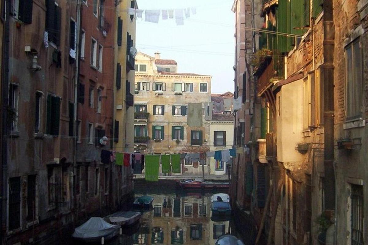 a view of a canal between two buildings with boats
