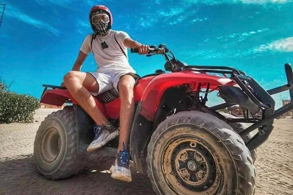 muž sediaci na kolesovom vozidle na pláži