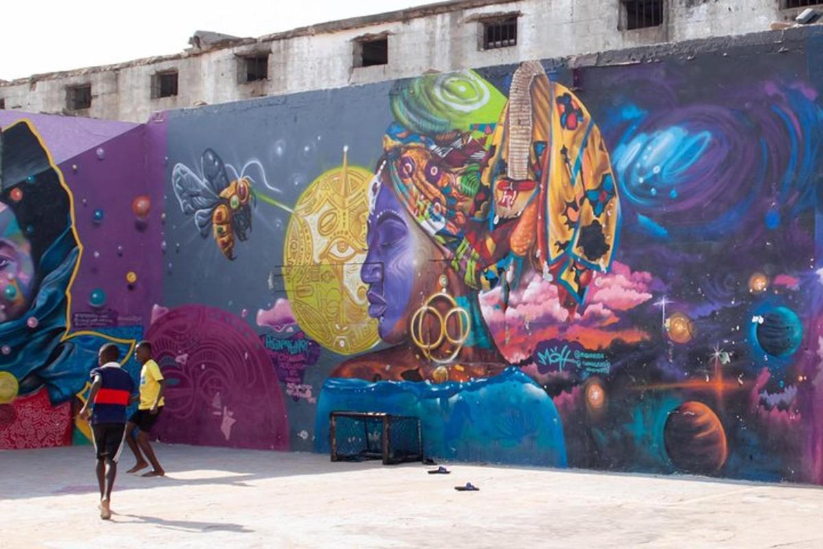 dua orang berjalan di hadapan dinding dengan mural