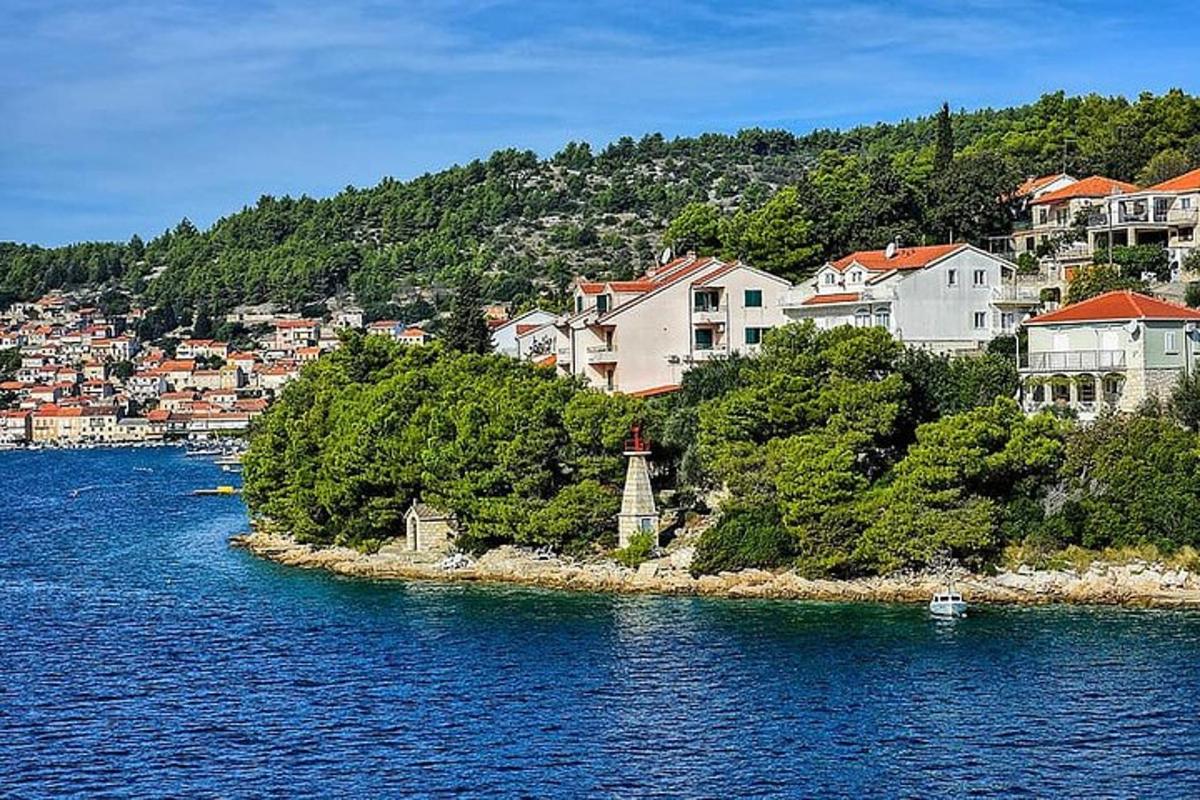 une petite île dans l'eau avec des maisons et un phare