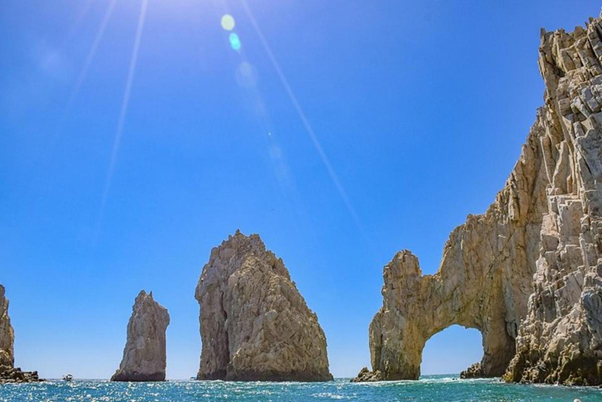 un gruppo di rocce nell'oceano con un cielo blu