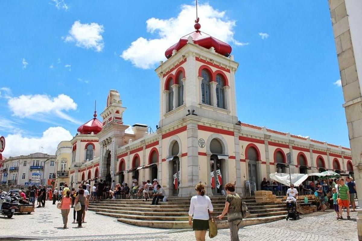 um grupo de pessoas caminhando ao redor de um prédio com uma torre