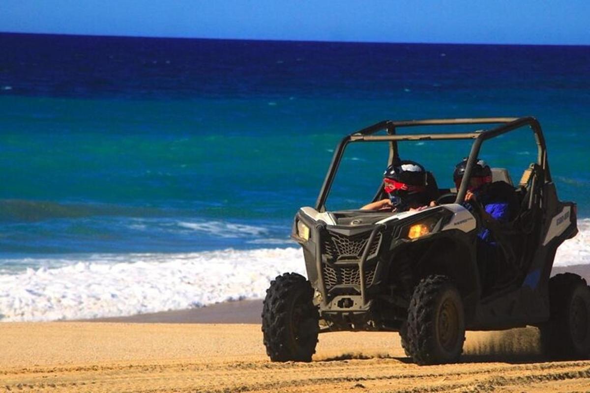 skupina ljudi, ki se vozijo v štirikolesniku na plaži