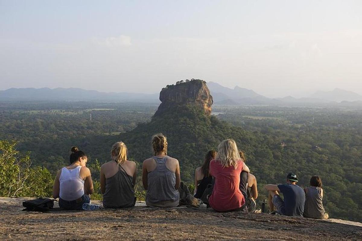eine Gruppe von Menschen, die auf einem Berggipfel sitzen