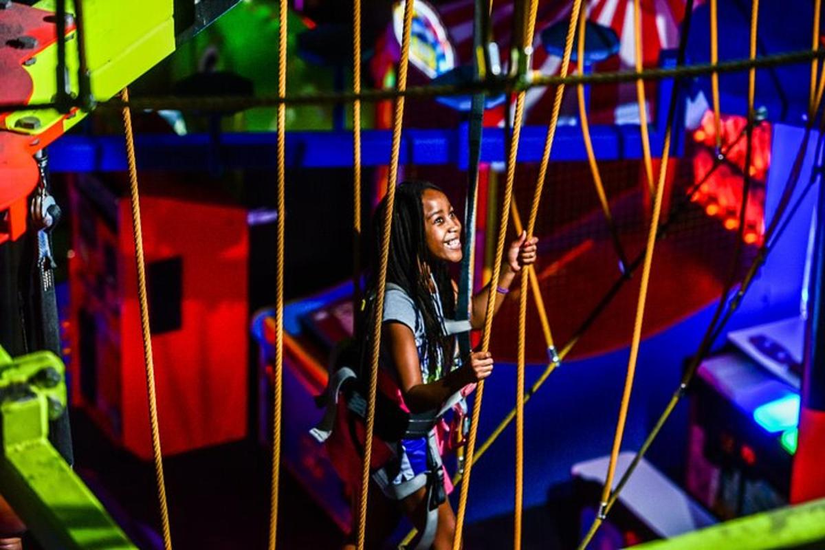 a young girl is playing on a climbing wall