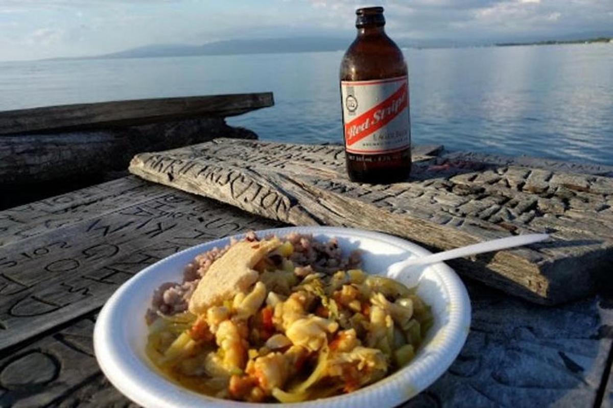 a bowl of food and a bottle of beer on a table