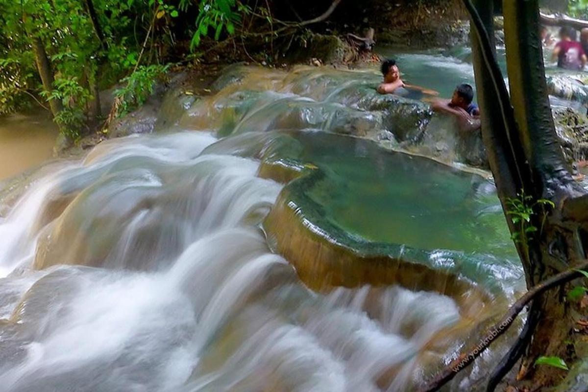 two people swimming in a pool of water in a river